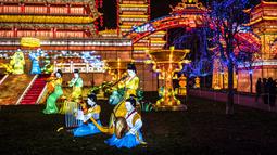 Pengunjung berdiri dekat lentera istana raksasa dalam Festival Lentera Gaillac di Taman Foucaud, Gaillac, Prancis, Rabu (12/12). Festival ini juga menandai berakhirnya perayaan untuk periode Tahun Baru China. (ERIC CABANIS/AFP)