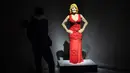 Seseorang berdiri di dekat patung "Courtney Red" yang terbuat dari susunan balok lego pada pameran Art of the Brick di Turin, Italia, Kamis (15/11). Pameran tersebut menampilkan berbagai patung lego karya seniman AS, Nathan Sawaya. (MARCO BERTORELLO/AFP)