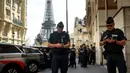 Petugas polisi berkumpul di sebuah jalan dekat Menara Eiffel jelang malam upacara pembukaan Paralimpiade Paris 2024, Selasa, 27 Agustus 2024 di Paris. (AP Photo/Thomas Padilla)