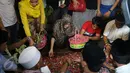 Istri Budi Anduk, Neneng Nurhayati menaburkan bunga di makam Budi Anduk, Bekasi, Senin (11/1/2016). Budi Anduk menghembuskan nafas terakhir pada usia 47 tahun di RS Dharmais, Jakarta. (Liputan6.com/Herman Zakharia)