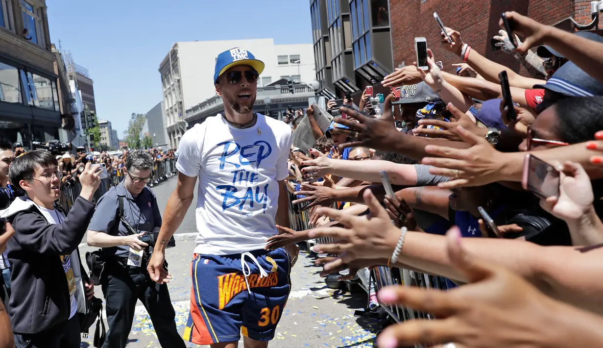 Pemain Guard Golden State Warriors, Stephen Curry saat menggelar parade Warriors 2018 usai menjuarai NBA 2018 di pusat kota Oakland, California, Amerika Serikat, (12/6). (AP Photo/Marcio Jose Sanchez)
