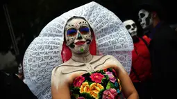 Seorang wanita berpakaian seperti "Catrina" ambil bagian dalam parade Hari Orang Mati di Reforma Avenue, Mexico City, 21 Oktober 2018. Hari kematian ini jadi hari libur nasional di negara-negara Amerika Latin, khususnya Meksiko. (RODRIGO ARANGUA/AFP)