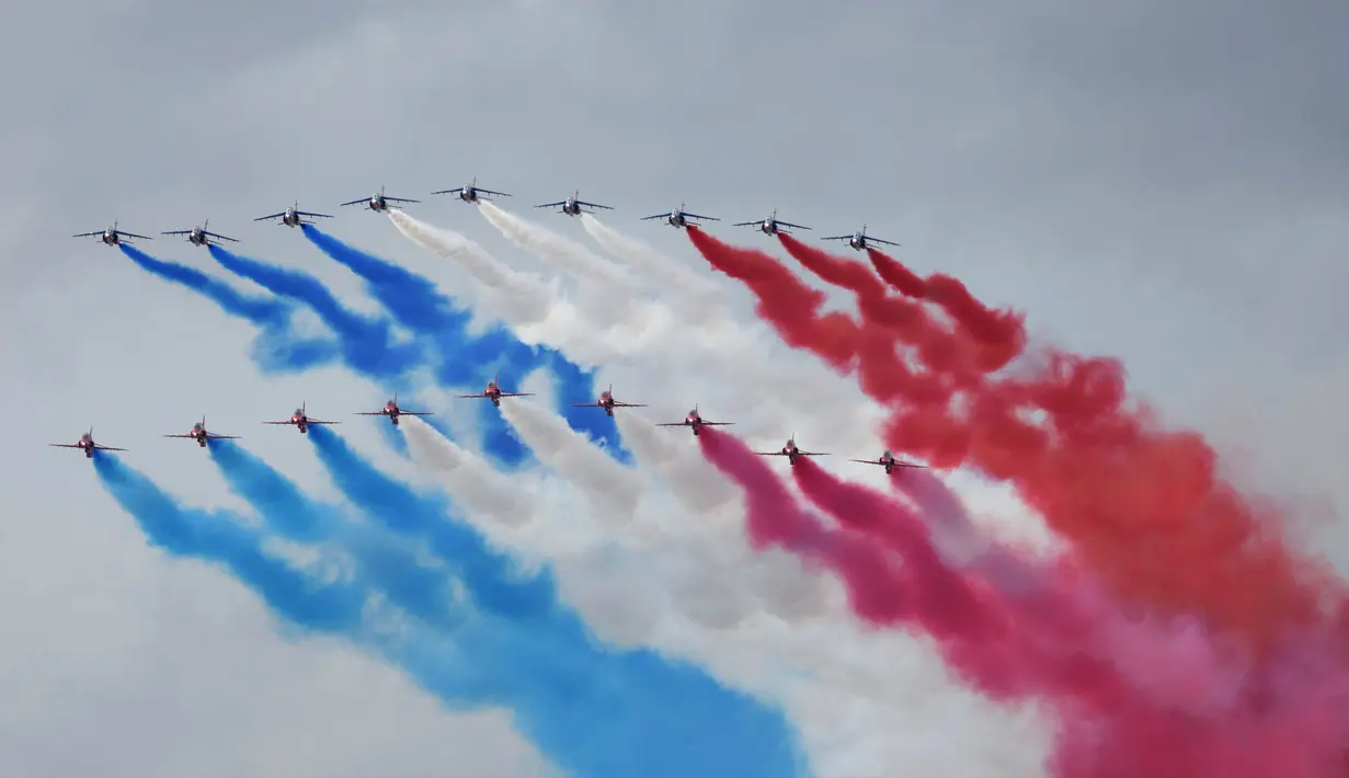 Tim terbang akrobatik Angkatan Udara Prancis "Patrouille de France" (PAF) dan tim aerobatik Angkatan Udara Kerajaan Inggris (RAF), "Red Arrows", melakukan terbang lintas selama upacara penyambutan resmi untuk Raja Inggris Charles III dan Ratu Inggris Camilla di Arc de Triomphe di Paris pada tanggal 20 September 2023. (Thomas SAMSON/AFP)