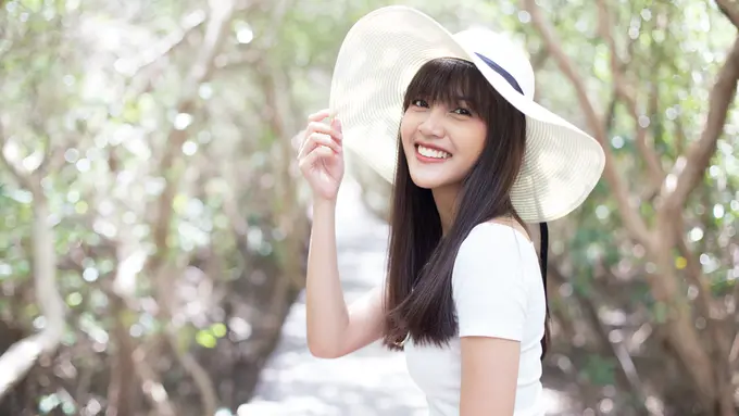 tersenyum memakai topi