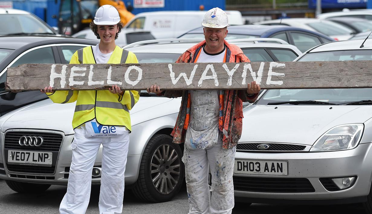 Dua orang fans menyambut kedatangan kembali Wayne Rooney ke Everton saat perkenalan dirinya di Goodison Park, Liverpool, Senin (10/7/2017). (AFP/Paul Ellis)