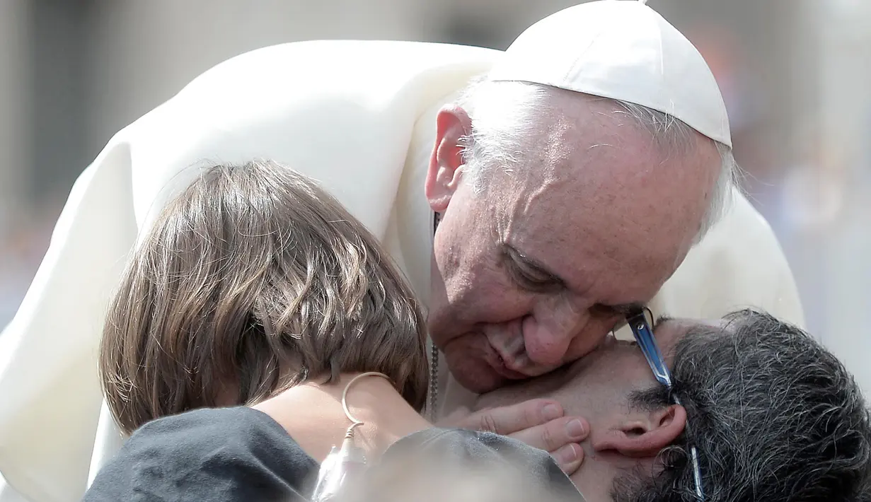 Paus Fransiskus mencium seorang umat setelah audiensi umum mingguan di Lapangan Santo Petrus, Vatikan pada 11 September 2013. (Filippo MONTEFORTE/AFP)