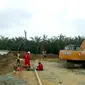 Petugas membersihkan lumpur hasil semburan gas di Pesantren Al Ihsan Pekanbaru. (Liputan6.com/M Syukur)
