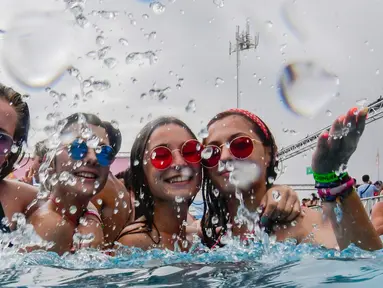 Sejumlah wanita bersuka ria mencipratkan air di kolam renang selama Festival Arenal Sound di Burriana, Spanyol (31/7/2019). Festival musik ini berlangsung dari 30 Juli sampai 4 Agustus 2019.  (AFP Photo/Jose Jordan)