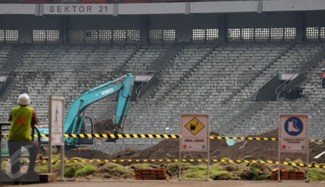 Pekerja mengawasi proses pengangkutan tanah lapangan bola di Stadion GBK Jakarta, Selasa (18/10). Pengerjaan renovasi Stadion GBK bagian persiapan jelang Asian Games 2018 dan ditargetkan selesai Oktober 2017. (Liputan6.com/Helmi Fithriansyah)