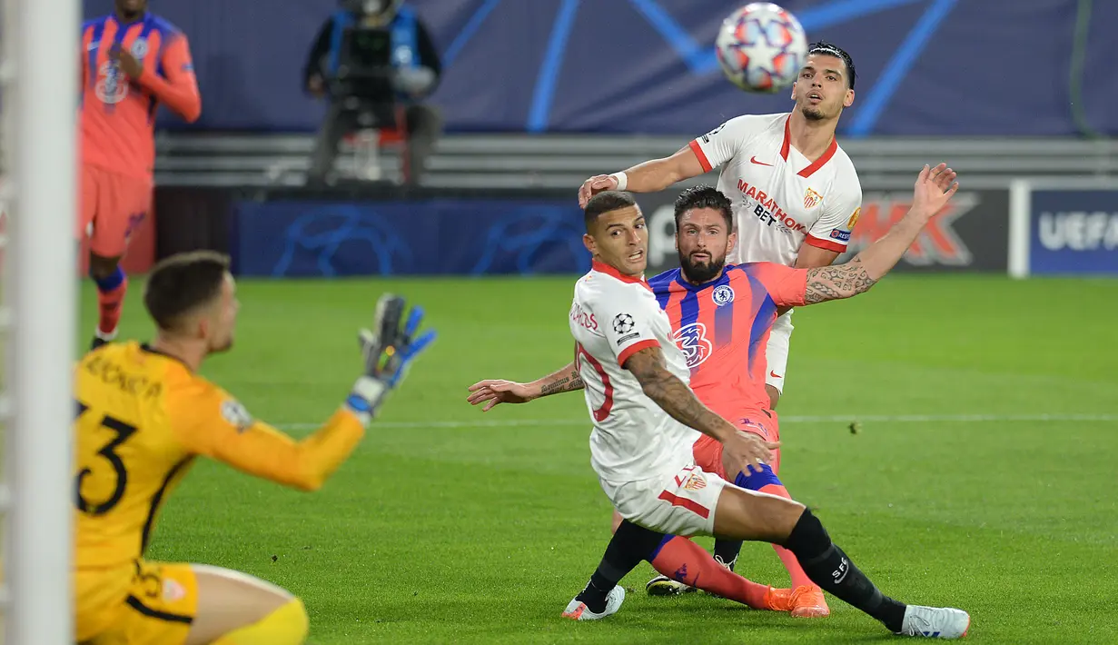 Striker Chelsea Olivier Giroud mencetak gol melewati kiper Sevilla Alfonso Pastor pada matchday kelima Grup E Liga Champions di Estadio Ramon Sanchez Pizjuan, Sevilla, Kamis (3/12/2020) dinihari WIB. Olivier Giroud memborong empat gol saat Chelsea mencukur Sevilla 4-0. (CRISTINA QUICLER/AFP)
