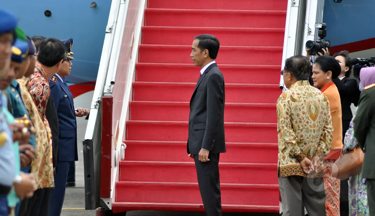 Presiden Jokowi (tengah) didampingi Ibu Negara, Iriana (kanan) dan Wapres Jusuf Kalla bersiap menaiki pesawat kepresidenan untuk melakukan kunjungan kenegaraan  di Bandara Halim Perdanakusuma, Jakarta, Minggu (22/3). (Liputan6.com/Faizal Fanani)
