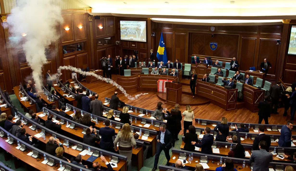 Sebuah gas air mata meledak dalam rapat parlemen di ibu kota Kosovo, Pristina, Rabu (21/3). Aksi anggota Partai Vatevendosje itu dilakukan demi mencegah pemungutan suara terkait masalah kesepatakan perbatasan dengan Montenegro. (AP Photo/Visar Kryeziu)