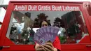 SPG menunjukkan voucher yang akan dibagikan secara cuma-cuma di dalam mobil boks Shopback di Plaza Festival  Kuningan, Jakarta, Kamis (24/5). Untuk mendapatkan uang, pengunjung harus mengundung aplikasi Shopback. (Liputan6.com/Fery Pradolo)