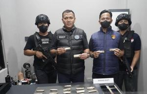 Kanit 1 Subdit 3 Ditresnarkoba Polda Metro Jaya AKP Arie Purwanto bersama barang bukti yang ganja seberat 107,17 gram yang disembunyikan di dalam drum pakan ikan. (Antara)