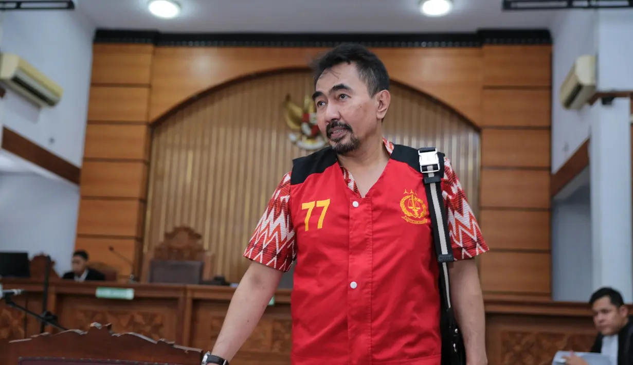 Siang tadi, guru spiritual artis itu datang mengenakan rompi tahanan warna merah. Ia mengaku tergangu dengan kamera wartawan yang terus menyorotnya. (Adrian Putra/Bintang.com)