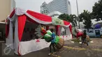 Pekerja membawa ondel-ondel di TPS 4 Kelurahan Gambir, Jalan Tanah Abang Timur, Jakarta, Selasa (18/4). Nantinya Presiden Joko Widodo akan melaksanakan pencoblosan hak suaranya pada Pilkada DKI 2017 di TPS tersebut. (Liputan6.com/Faizal Fanani)