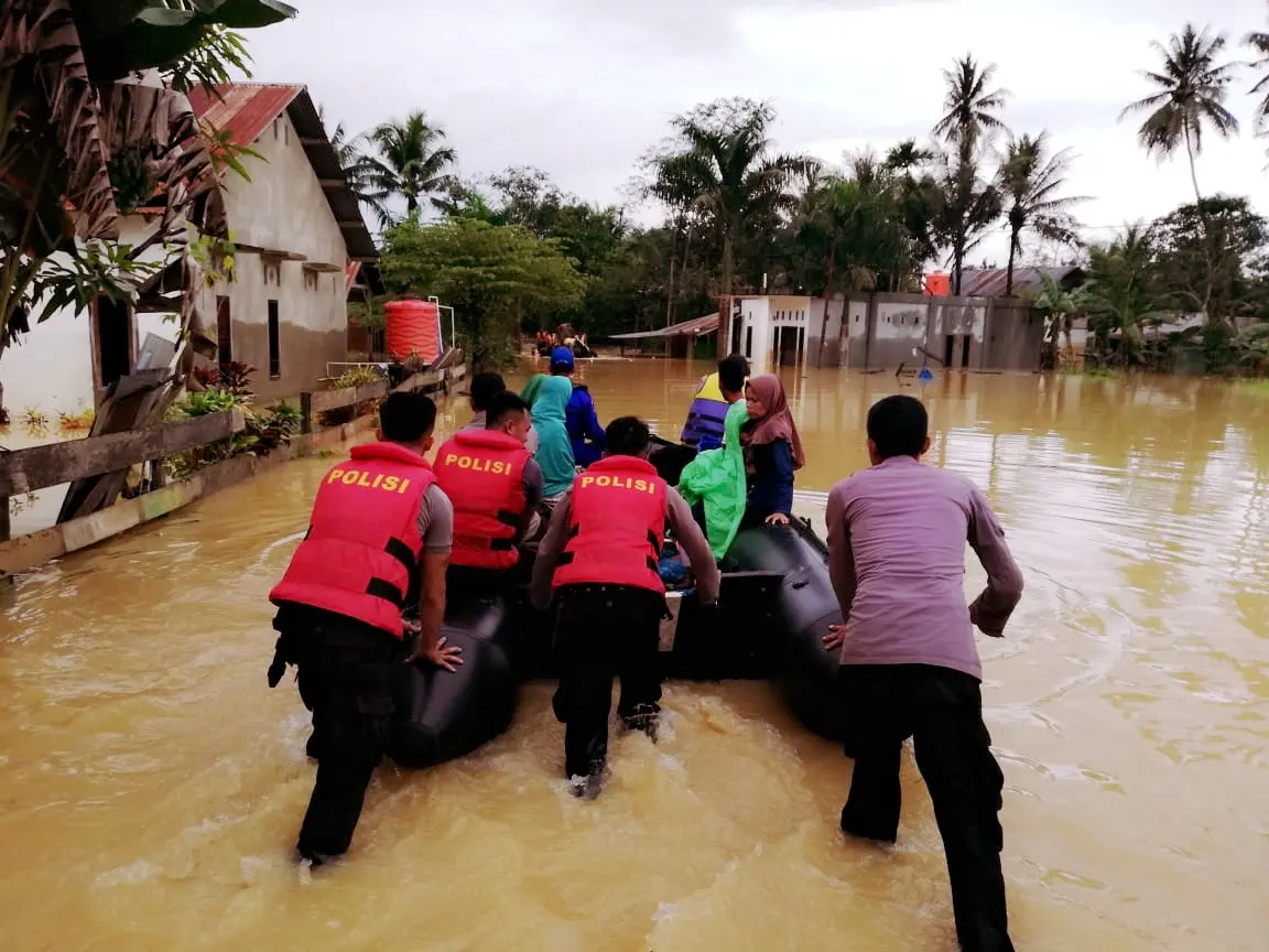 Warga yang berada di lokasi terisolir karena banjir, diantar dengan perahu karet menuju TPS. 9Liputan6.com/Ahmad Akbar)