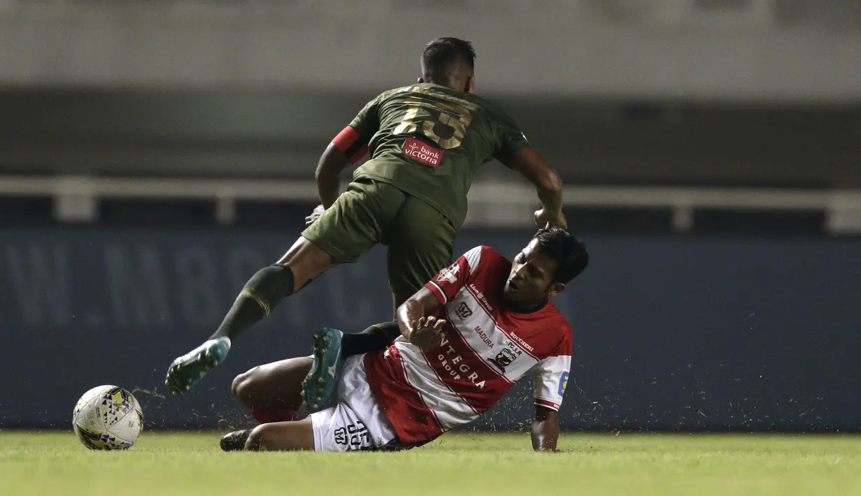 Gelandang Madura United, Zulfiandi, merebut bola dari pemain Tira Persikabo pada laga Shopee Liga 1 di Stadion Pakansari, Bogor (12/7). Tira bermain imbang 2-2 atas Madura. (Bola.com/Yoppy Renato)