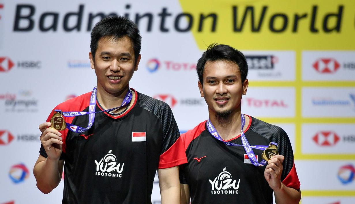 Pasangan Indonesia, Hendra Setiawan/Mohammad Ahsan melakukan selebrasi usai menjuarai Kejuaraan Dunia Bulutangkis 2019 setelah mengalahkan wakil Jepang, Takuro Hoki/Yugo Kobayashi, Minggu (25/8). Indonesia menang 25-23, 9-21, 21-15. (AFP/Fabrice Coffrini)