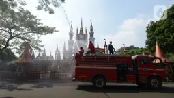 Petugas pemadam kebakaran melakukan penyemprotan cairan disinfektan tempat wisata di Taman Mini Indonesia Indah (TMII), Jakarta, Rabu (10/6/2020). Rencananya, TMII kembali dibuka untuk umum pada 20 Juni 2020 dengan menerapkan tatanan kenormalan baru. (merdeka.com/Imam Buhori)