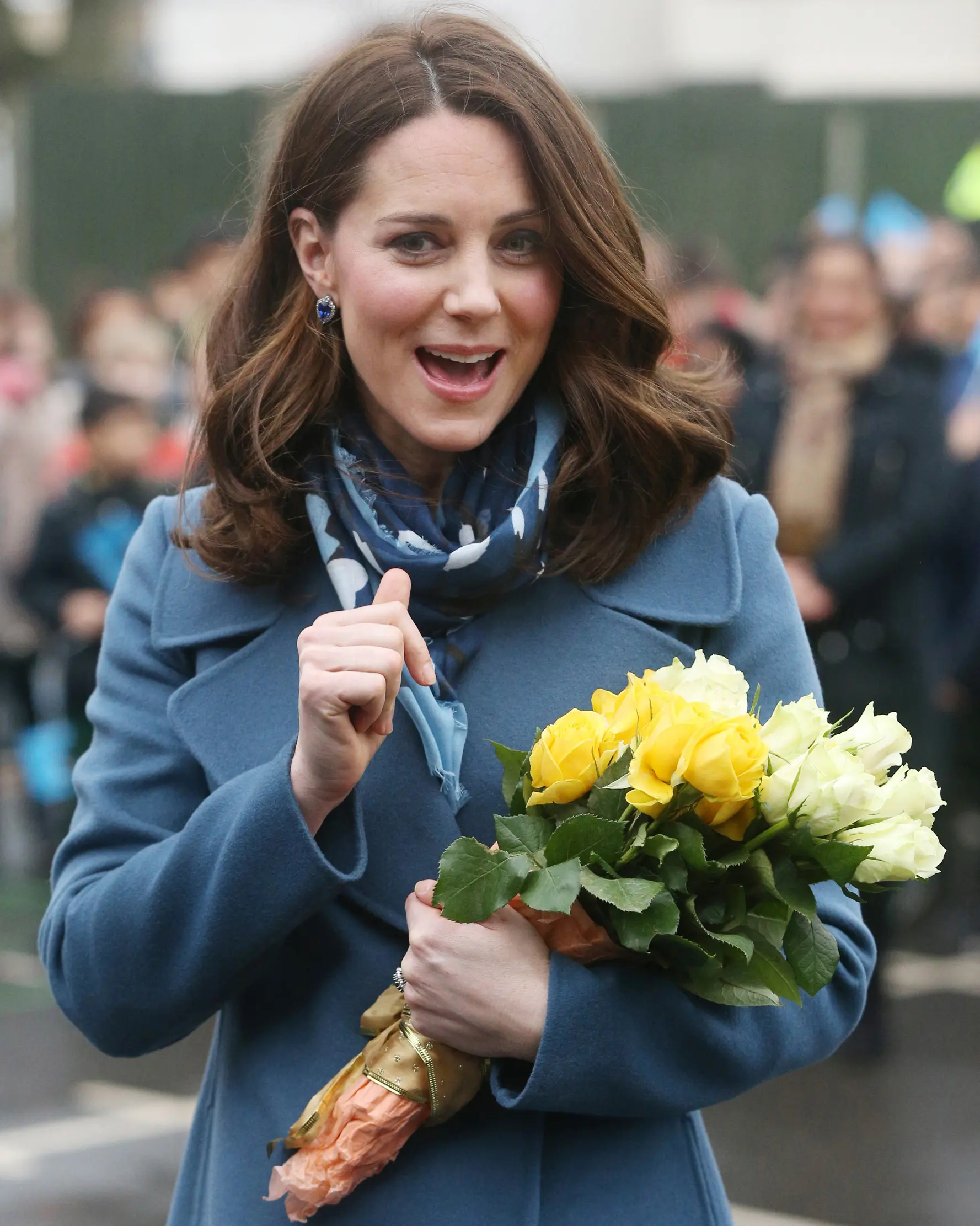 Kate Middleton tersenyum semringah usai menerima hadiah bunga dari anak-anak saat mengunjungi Roe Green Junior School di London, Inggris, Selasa (23/1). Kunjungan sekaligus peluncuran program kesehatan mental untuk anak-anak. (Jonathan Brady/POOL /AFP)