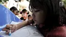 Seorang anak belajar mewarnai gambar saat program Literasi Kejujuran di Taman Bacaan Masyarakat (TBM) Saung Manggar, Pondok Kelapa, Jakarta, Minggu (24/3). (merdeka.com/Iqbal S. Nugroho)