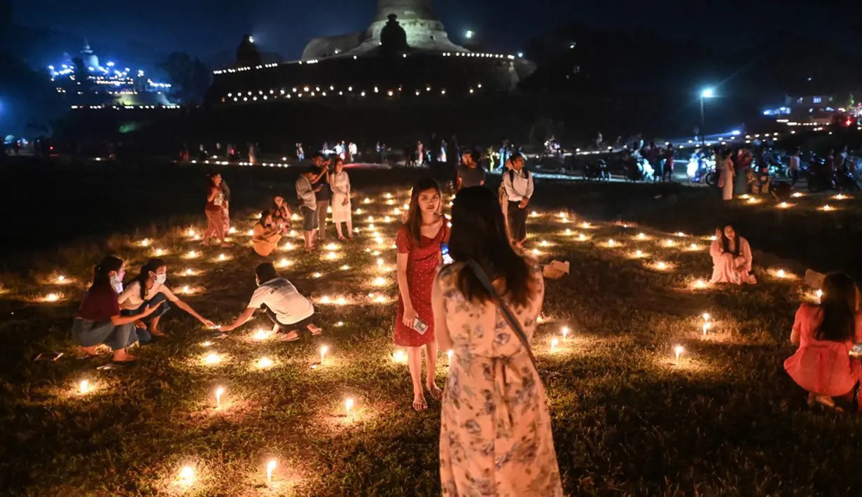 Orang-orang mengambil bagian dalam Festival Tazaungdaing di pagoda di Mrauk U, Rakhine, Myanmar, 18 November 2021. Tazaungdaing adalah Festival Bulan Purnama yang diadakan setiap tahun pada bulan purnama, bulan kedelapan dalam kalender Burma. (STR/AFP)