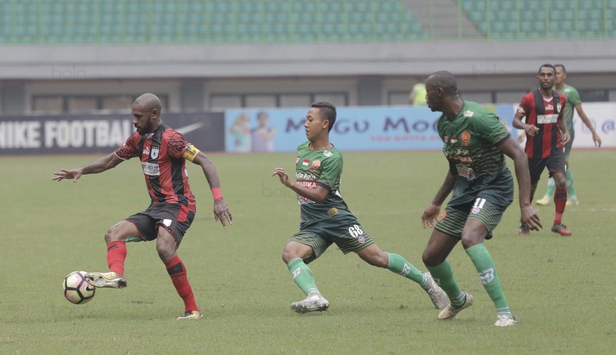 Pemain Persipura Jayapura, Boaz Solossa melewati adangan para pemain PS TNI pada lanjutan Liga 1 2017 di Stadion Patriot, Bekasi (4/11/2017). PS TNI menang 2-1. (Bola.com/Rizal Febriansyah)