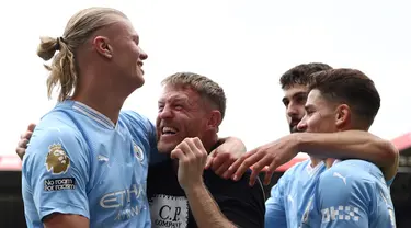 Striker Manchester City #09 Erling Haaland (kiri) merayakan mencetak gol pertama bersama penggemar Man City dan rekan satu timnya saat melawan Sheffield United pada pekan ketiga Liga Inggris 2023/2024 di Bramall Lane, Minggu (27/8/2023). (Photo by Darren Staples / AFP)