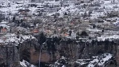 Kota Bcharre yang tertutup salju, menghadap ke lembah Qadisha di gunung Lebanon, di utara ibu kota Beirut (22/2/2022).(AFP/Ibrahim Calhoub)