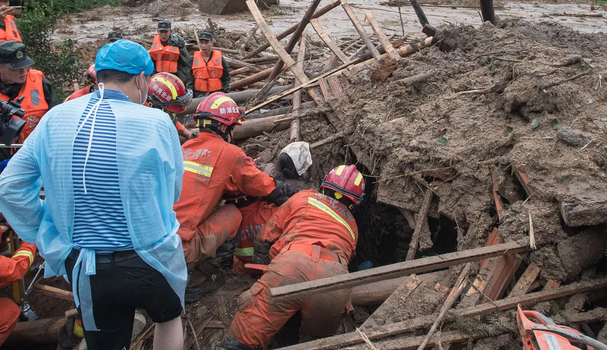 Tim penyelamat mengeluarkan wanita lansia dari tanah longsor di Yuanshan, sebuah desa di Kota Dahe, Provinsi Hubei, China (8/7/2020). Seorang wanita lansia berhasil diselamatkan beberapa jam setelah dirinya dan delapan orang lainnya terkubur akibat longsor yang dipicu hujan. (Xinhua/Xiao Yijiu)