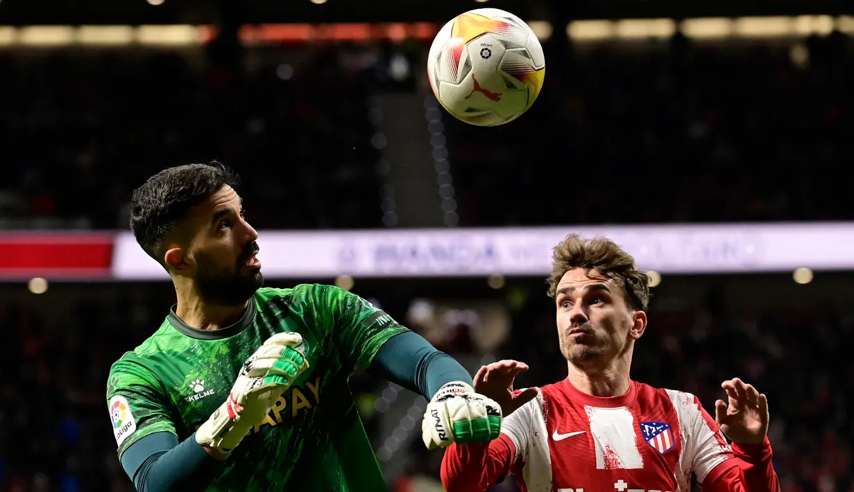 Pemain depan Atletico Madrid Antoine Griezmann (kanan) dan kiper Deportivo Alaves Fernando Pacheco mengawasi bola dalam lanjutan La Liga Spanyol di Stadion Wanda Metropolitano, Minggu (3/4/2022) dinihari WIB. Atletico Madrid menang telak dengan skor 4-1 atas Deportivo. (JAVIER SORIANO / AFP)