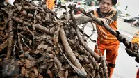 Petugas kebersihan menata bungkusan kabel yang menyumbat saluran air di Jalan Merdeka Selatan, Jakarta, Senin (29/2). Basuki Tjahaja Purnama (Ahok) mengatakan adanya dugaan sabotase banjir akibat limbah kulit kabel itu. (Liputan6.com/Faizal Fanani)