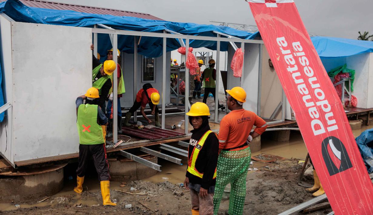 Melalui kerja sama ini, Danantara menginisiasi program pemulihan hunian masyarakat. Tampak dalam foto, unit-unit perumahan sementara yang dibangun oleh Danantara, Badan Pengelola Investasi (BPI) strategis Indonesia, sedang dibangun untuk warga yang dievakuasi akibat banjir bandang, seiring dengan berlanjutnya pembangunan di 14 lokasi di Aceh Tamiang, provinsi Aceh, pada Kamis 8 Januari 2026. (ADITYA AJI/AFP)