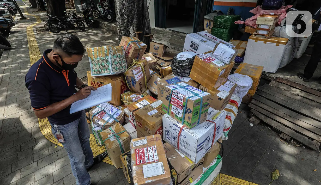 Pegawai jasa ekspedisi mengecek barang yang akan dikirim ke daerah di Pasar Senen, Jakarta Pusat, Selasa (5/5/2020). Barang tersebut akan dibawa ke Stasiun Barang Kampung Bandan untuk dibawa ke daerah-daerah di Jawa Tengah dan Jawa Timur dengan menggunakan kereta. (Liputan6.com/Faizal Fanani)