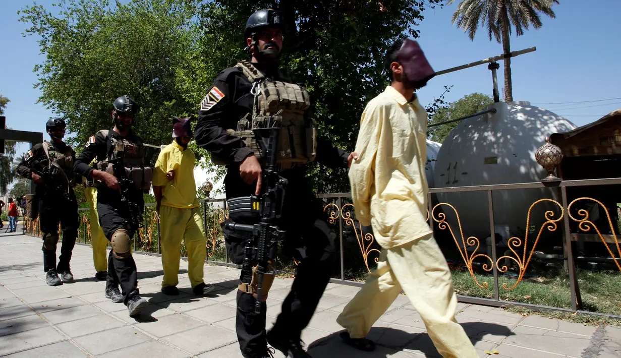 Militer Irak menggiring sejumlah pria yang diduga sebagai militan ISIS saat akan konferensi pers di Irak direktorat intelijen militer di Baghdad (7/9). Militer Irak berhasil menangkap beberapa militan ISIS beserta senjata. (REUTERS/Khalid al Mousily)