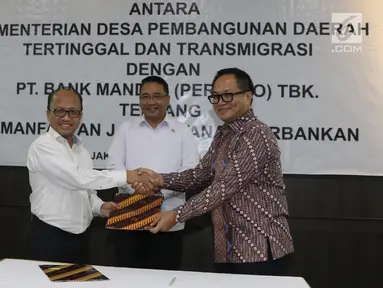 Mendes PDTT Eko Putro Sandjojo (tengah) menyaksikan Sekjen Kemendes PDTT Anwar Sanusi (kiri) dan Dirut Bank Mandiri Kartika Wirjoatmodjo (kanan) bertukar naskah MoU kerja sama di Kantor Kemendes PDTT, Jakarta, Senin (30/9/2019). (Liputan6.com/Angga Yuniar)