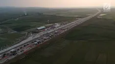 Foto udara antrean kendaraan pemudik di jalur tol fungsional Gerbang Tol (GT) Kertasari, Tegal, Jawa Tengah, Minggu (10/6). Memasuki H-5 lebaran GT Kertasari mulai dipadati kendaraan pemudik dari arah Jakarta. (Liputan6.com/Arya Manggala)