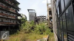 Selain diselimuti tanaman liar, bangunan yang masih setengah jadi terlihat kusam dan tidak terawat, Jawa Barat, Minggu (4/9). Proyek Hambalang ini sudah 4 tahun mangkrak. (Liputan6.com/Helmi Afandi)