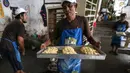 Karyawan membawa roti yang akan dipanggang ke dalam tungku di Toko Roti GO, Purwokerto, Jawa Tengah, Senin (22/4). Memasuki usia ke 121 tahun, toko roti yang berdiri sejak tahun 1898 ini dibuat mengunakan peralatan tradisional dan tanpa bahan pengawet. (Liputan6.com/Fery Pradolo)