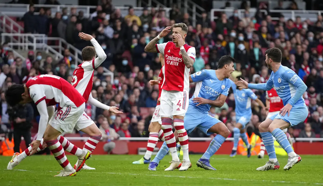 Pemain Arsenal (kiri) bereaksi setelah pemain Manchester City Rodrigo mencetak gol pada pertandingan sepak bola Liga Inggris di Stadion Emirates, London, Inggris, 1 Januari 2022. Manchester City menang 2-1. (AP Photo/Matt Dunham)
