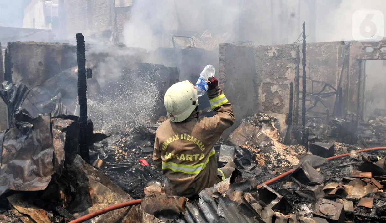 Petugas pemadam kebakaran meminum air saat berusaha menjinakkan api yang melahap permukiman warga di Jalan Kebon Jeruk 13, Taman Sari, Jakarta Barat, Minggu (6/10/2019). Kebakaran menghanguskan puluhan rumah di dua kelurahan, Taman Sari dan Mapar. (merdeka.com/Iqbal Nugroho)