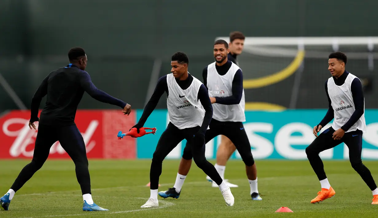 Para pemain Inggris bermain lempar-lemparan ayam selama mengikuti sesi latihan di Repino, Rusia (10/7). Inggris akan bertanding melawan Kroasia pada babak semifinal Piala Dunia 2018. (AFP Photo/Adrian Dennis)