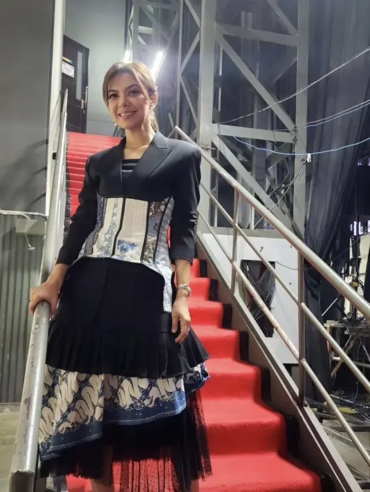 Najwa Shihab tampil mengenakan koleksi dari desainer Wilsen Willim. Dengan atasan blazer hitam dipadukan obi batik dan rok beraksen batik. [@najwashihab]