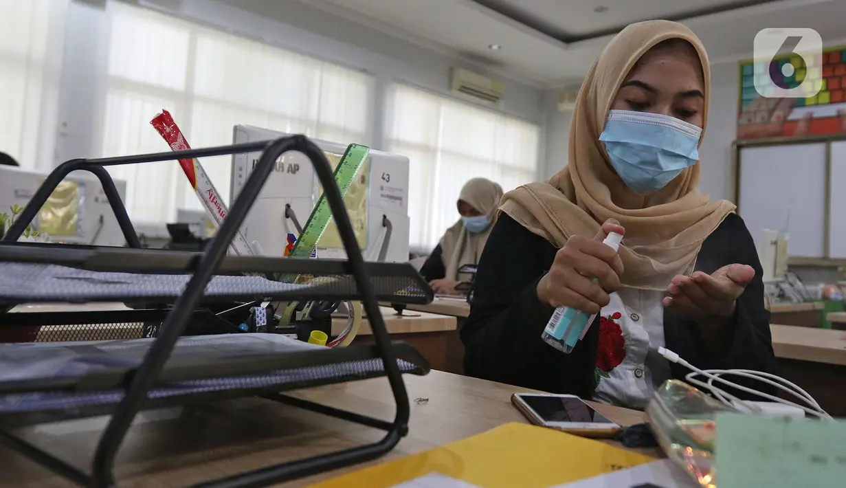 Murid sedang menggunakan hand sanitizer (pembersih tangan) sebelom melakukan kegiatan di SMKN 51, Jakarta, Rabu (7/4/2021). SMKN 51 melakukan uji coba masuk sekolah dan Uji Sertifikasi Kompetensi (USK) dengan protokol kesehatan yang ketat. (Liputan6.com/Herman Zakharia)