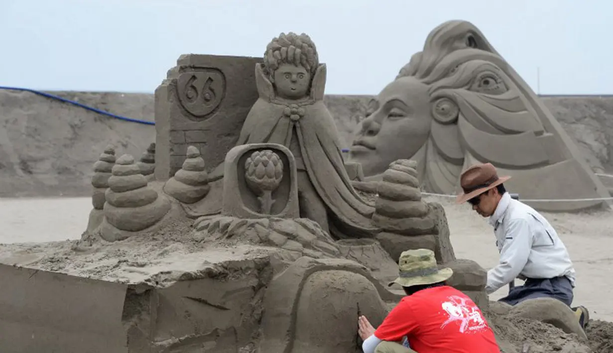 Hingga H-2 penyelenggaraan pameran patung pasir di pantai Yasashigaura, Asahi, Chiba, Jepang, (13/7/2014), sejumlah seniman patung masih berusaha menyelesaikan karya mereka. (AFP PHOTO/Toshifumi Kitamura)