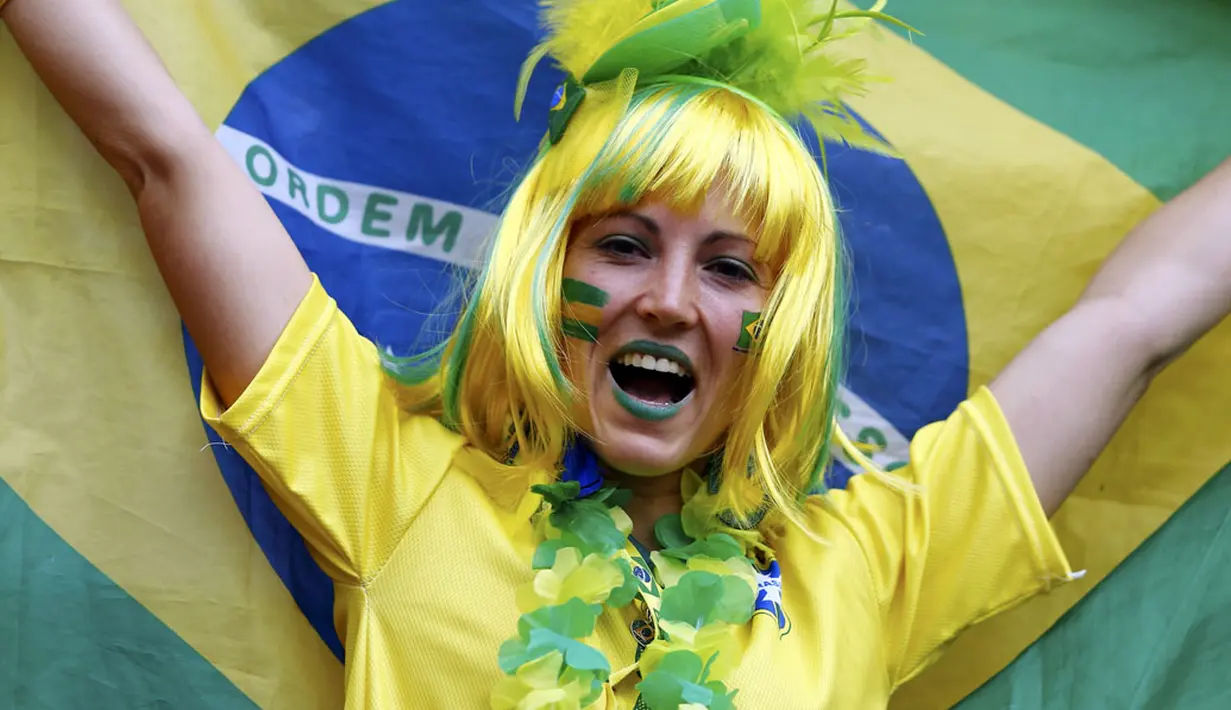 Gaya salah satu suporter wanita Brasil saat menyaksikan langsung Daniel Alves dkk berlaga melawan Kamerun di Stadion Nasional Brasil, (23/6/2014). (REUTERS/Dominic Ebenbichler)