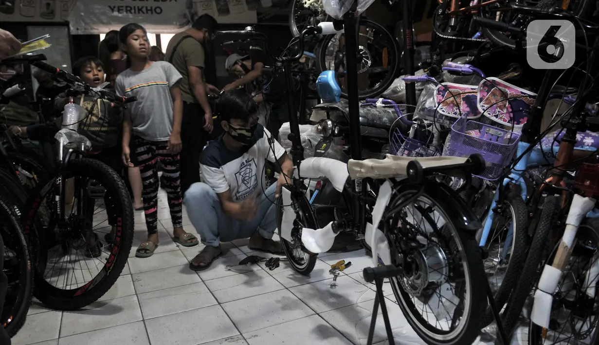 Pekerja merakit sepeda yang telah dibeli di salah satu toko di Kramat Jati, Jakarta, Minggu (21/6/2020). Dalam sebulan terakhir, penjualan sepeda di Ibu Kota meningkat tajam seiring minat dan tren warga yang melonjak menggunakan transportasi gowes itu di masa pandemi. (merdeka.com/Iqbal Nugroho)