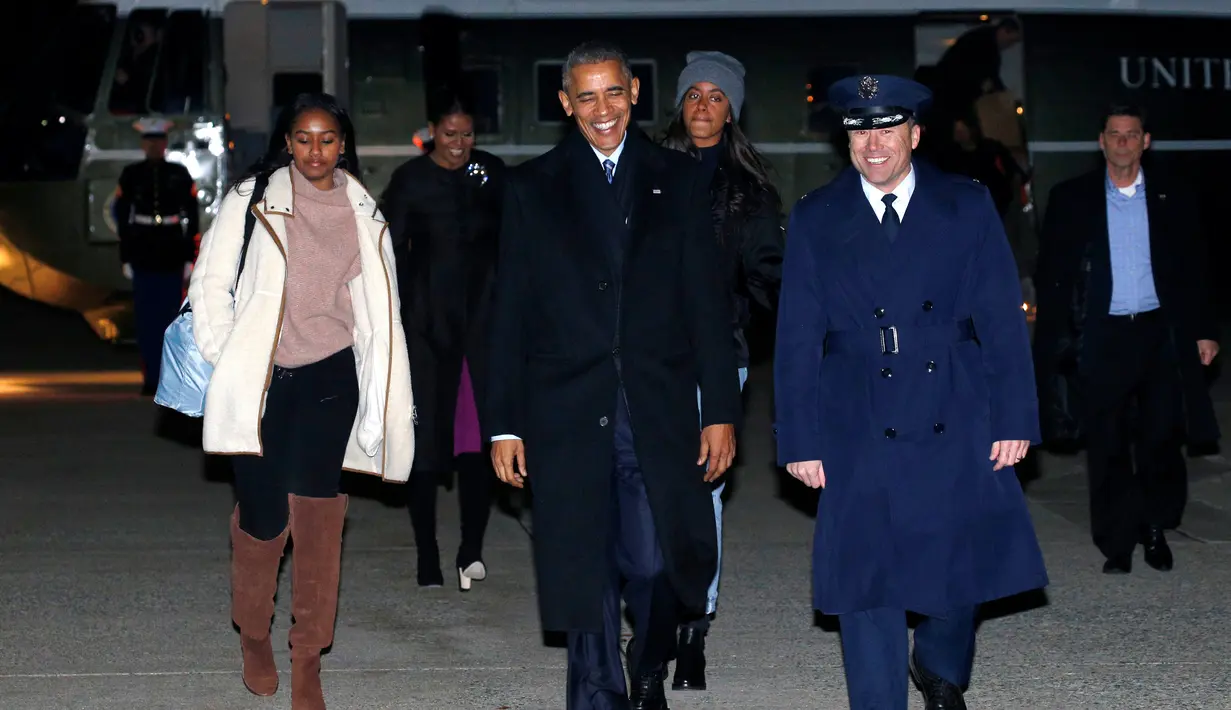 Presiden Barack Obama dan keluarga berjalan menuju pesawat Air Force One di Joint Base Andrews di Maryland, AS (16/12). Obama akan berlibur ke Hawaii untuk merayakan Natal disana. (REUTERS / Kevin Lamarque)