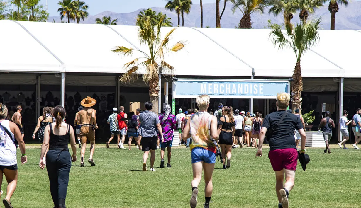 Pengunjung berlarian menuju tenda merchandise di Coachella Music and Arts Festival, Empire Polo Club, Indio, California, Amerika Serikat, 16 April 2022. Niki Zefanya dan Rich Brian menjadi musisi Indonesia pertama yang tampil di Coachella. (Photo by Amy Harris/Invision/AP)